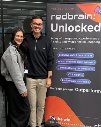 Two members of the Redbrain team beside the Redbrain: Unlocked banner at the CSS Summit